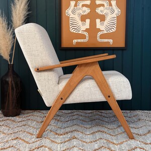 Side profile of handmade beech lounge chair with ivory upholstery, compact for small living rooms