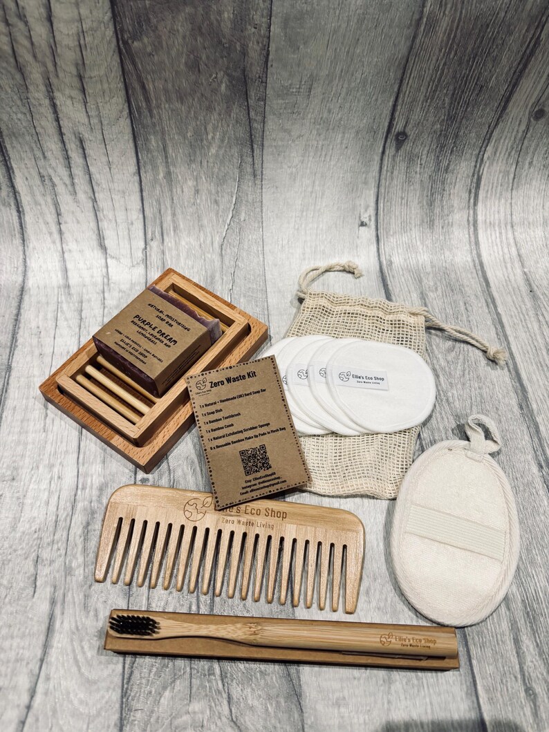 May include: A zero waste kit featuring a wooden soap dish with a bar of soap, a wooden comb, a bamboo toothbrush, reusable cotton pads in a drawstring bag, and a natural exfoliating sponge. The kit includes a card that reads "Zero Waste Kit".