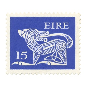 May include: A blue postage stamp with a white Celtic wolf design and the word "EIRE" and the number "15" printed on it.