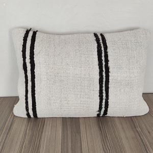 May include: White pillow with two black stripes down the center.