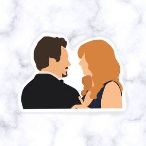 May include: A sticker featuring a minimalist illustration of a man and woman facing each other. The man is in a black suit, and the woman has red hair and a dark blue dress. The background is white with a marble pattern.