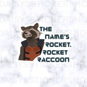 Op de afbeelding: Een sticker met een cartoon afbeelding van Rocket Raccoon uit Guardians of the Galaxy. De sticker heeft een witte achtergrond met zwarte tekst die "The name's Rocket. Rocket Raccoon." luidt.