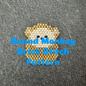 Puede incluir: Un patrón de mono de cuentas en punto de ladrillo, con cuentas doradas, crema y negras. El texto "Round Monkey Brick Stitch Pattern" está superpuesto en azul. El diseño del mono está centrado en un fondo gris.