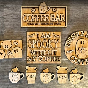 May include: A set of seven wooden signs with a Halloween theme. The signs feature ghosts, coffee cups, and the text "I am spooky without my coffee", "Freshly Brewed Coffee", and "Coffee Bar".