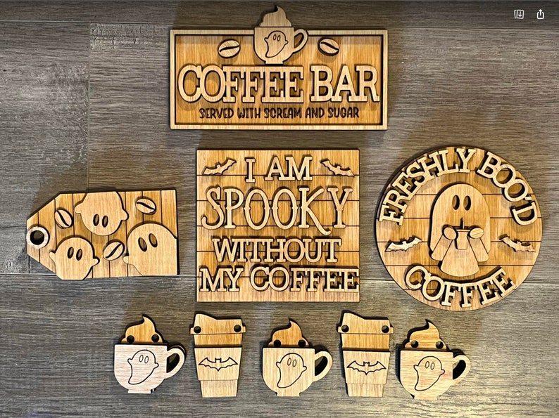 May include: A set of seven wooden signs with a Halloween theme. The signs feature ghosts, coffee cups, and the text "I am spooky without my coffee", "Freshly Brewed Coffee", and "Coffee Bar".