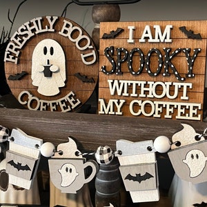 May include: A wooden sign with the text "I am spooky without my coffee" in black and white letters with white polka dots. The sign is decorated with bats and a ghost holding a coffee cup.
