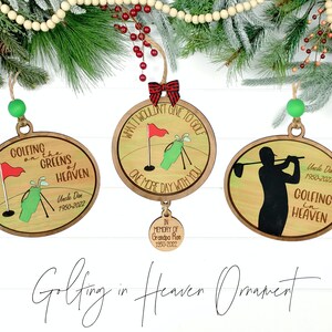 May include: Three wooden Christmas ornaments with a golf theme. The ornaments are round and feature a golfer, a golf bag, and a golf flag. The ornaments are decorated with the text "Golfing on the Greens of Heaven", "What I wouldn't give to golf one more day with you", and "Golfing in Heaven".