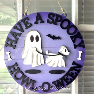 Può includere: Cartello rotondo di Halloween con sfondo viola e scritta nera "Have a Spooky Howl-O-Ween". Raffigura un fantasma bianco che porta a spasso un cane bianco, un pipistrello nero e due ossa bianche. Appeso con uno spago.