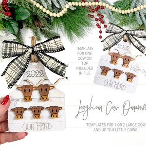 May include: A wooden Christmas ornament shaped like a cow's head with a plaid bow. The ornament has the year 2022 and the words "Our Herd" written on it. There are four smaller cow heads on the ornament with names written on them. The ornament is hanging from a Christmas tree.