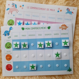 Può includere: Un grafico blu e bianco con il titolo "MON COMPORTEMENT" e i giorni della settimana elencati in alto. Il grafico ha un'illustrazione di dinosauro e adesivi a forma di stella verde.