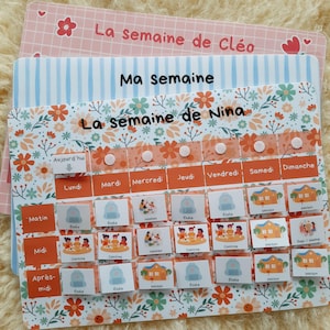 Peut inclure: Un tableau d'emploi du temps hebdomadaire coloré avec le texte "La semaine de Nina" et "Ma semaine". Le tableau présente un motif floral, avec les jours de la semaine et des créneaux horaires pour les activités. Comprend des étiquettes comme "Ecole" et "Cantine".