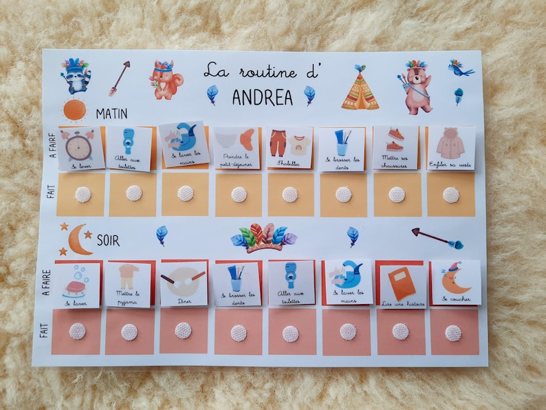 May include: A white board with a colorful routine chart for a child named Andrea. The chart has two columns, one for morning and one for evening, with a list of activities to complete. Each activity has a corresponding picture and a check box to mark when it is completed.