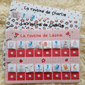 Peut inclure: Trois tableaux de tâches colorés pour enfants. Le tableau du haut a un fond blanc avec des cœurs rouges et le texte "La routine de Charlie". Le tableau du milieu a un fond imprimé léopard avec le texte "La routine de Camille". Le tableau du bas est rose avec le texte "La routine de Léonie".