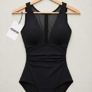 Peut inclure: Un maillot de bain une pièce noir doté d'un décolleté en V avec un panneau en maille transparente et une garniture tressée verticale. Le corsage présente des fronces latérales pour une texture plissée et une étiquette blanche POSHPONI.
