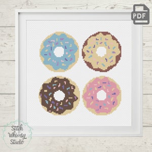 Peut inclure: Modèle de point de croix représentant quatre donuts avec des glaçages et des pépites de couleurs différentes. Les donuts sont bleus, bruns, bruns avec des pépites roses et roses.