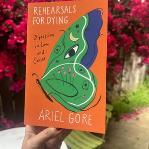May include: An orange book cover with the title "REHEARSALS FOR DYING" and the author's name, "ARIEL GORE." The cover features a green butterfly design with blue and white accents. The book's subtitle is "Digressions on Love and Cancer."