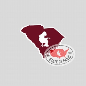 May include: A sticker featuring a maroon outline of South Carolina with a white silhouette of a musician playing a guitar. A circular sticker with a red map of the U.S. and the text "STATE OF PANIC" is also included.