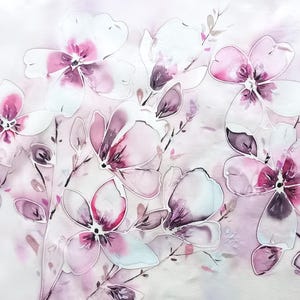 Peut inclure: Un textile orné d'un motif floral de style aquarelle avec des fleurs rose tendre, magenta et blanches. Le design comprend des tiges et des feuilles délicates dans des tons violets atténués, sur un fond rose pâle clair à la finition lisse.