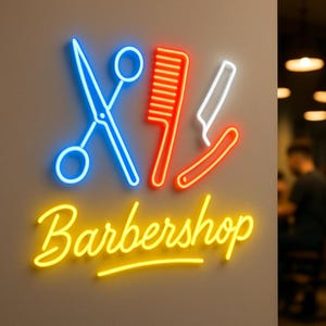 以下が含まれることがあります： 青いハサミ、オレンジ色の櫛、白いストレートカミソリが描かれたネオンサインで、その下に黄色い筆記体でBarbershopと書かれています。壁に取り付けられたこのサインは明るく輝き、古典的な理髪店の道具をネオンで表現しています。