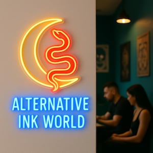 May include: Neon sign featuring a crescent moon and a snake in orange and yellow. The text "ALTERNATIVE INK WORLD" is displayed in blue neon below the sign. The sign is mounted on a white wall.