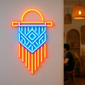 May include: A neon wall art piece in the shape of a macrame design. The art features a blue and yellow color scheme, with a geometric pattern in the center and vertical lines at the bottom. The art is mounted on a light gray wall.
