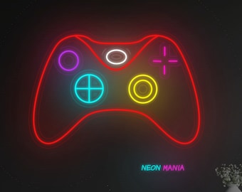 May include: A neon sign shaped like a video game controller with colorful buttons and the text "NEON MANIA" below it. The sign is mounted on a dark wall above a blue couch.