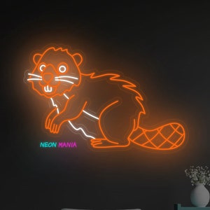 May include: Orange neon sign of a beaver with the text "NEON MANIA" underneath. The sign is hanging on a dark wall above a grey sofa.