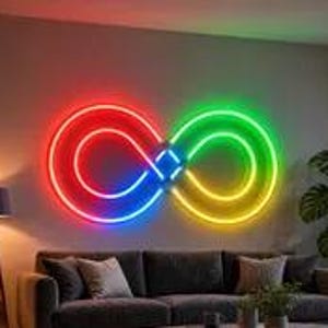 Puede incluir: Un letrero de neón montado en la pared con forma de símbolo de infinito que presenta un degradado vibrante de rojo, azul y verde. El letrero está colocado horizontalmente sobre un sofá gris oscuro, proyectando un brillo intenso en la pared.