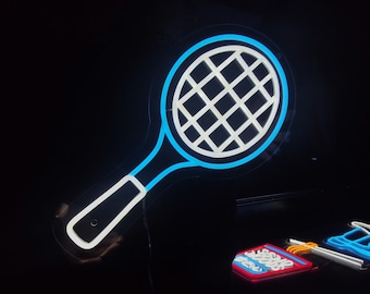 May include: A blue neon sign shaped like a tennis racket with a white outline. The racket is on a black background.