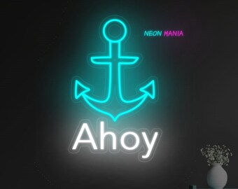 Puede incluir: Un letrero de neón con un ancla azul y la palabra "Ahoy" en blanco. El letrero está montado en una pared negra sobre un sofá azul en una sala de estar.