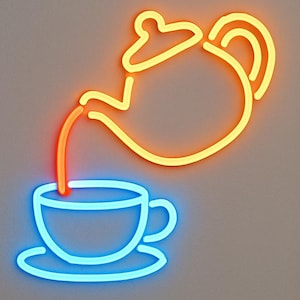 May include: A neon wall sign featuring a yellow teapot pouring a stream of orange liquid into a light blue teacup resting on a saucer. The design is composed of glowing linear tubes that create a simple outline of a tea service set.