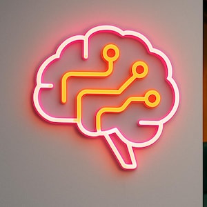 May include: A neon sign in the shape of a brain with a circuit board design. The sign has a pink outline and yellow and orange internal details. The sign is mounted on a gray wall.