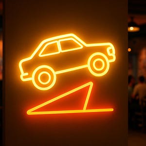 May include: A neon sign depicting a car driving up a ramp, illuminated in a warm orange glow. The car's outline and the ramp are clearly defined against a dark background, creating a striking visual effect. The sign is likely for a business related to cars.
