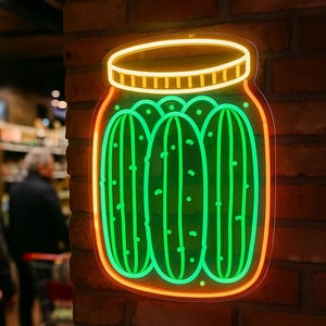 May include: Neon sign depicting a jar of pickles, with three green pickles inside. The jar has a yellow lid and a red outline, mounted on a brick wall. The neon sign is a decorative element.