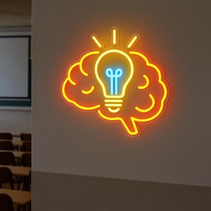 Op de afbeelding: Een neonbord met een hersenvorm met een gloeilamp in het midden. De hersenen zijn omlijnd in oranje, met de gloeilamp in blauw en geel. Het bord is op een witte muur gemonteerd.