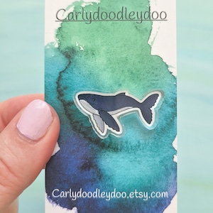 May include: A clear sticker with a blue whale illustration on a white card with a watercolor background. The card has the text "Carlydoodleydoo" at the top and "Carlydoodleydoo.etsy.com" at the bottom.