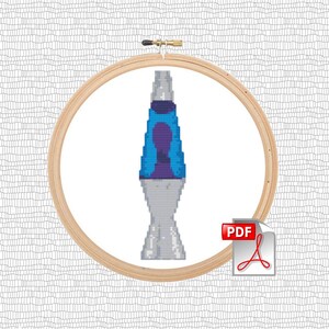 May include: A cross-stitch pattern of a blue and purple lava lamp in a wooden embroidery hoop. The pattern is available as a PDF download.