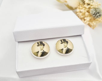 May include: A pair of silver cufflinks featuring a vintage portrait of a man in a top hat and suit. The cufflinks are presented in a white gift box, ideal for a special occasion.