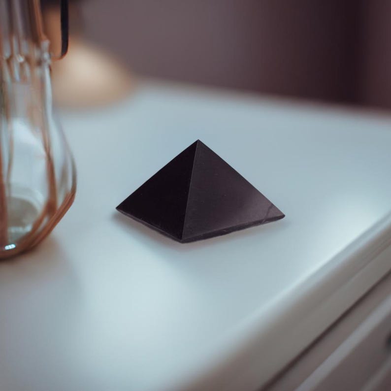May include: A black obsidian pyramid, a type of crystal used in healing and meditation.