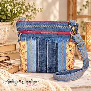 May include: A crossbody bag crafted from blue denim and yellow floral fabric, featuring a red zipper, frayed denim trim, and a detachable strap with a beaded charm. The bag displays a patchwork design with vertical stripes and embroidered details.
