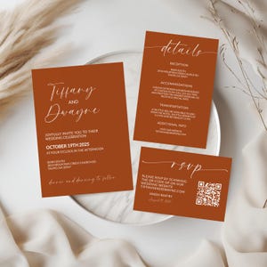 Peut inclure: Ensemble de faire-part de mariage terracotta avec une écriture blanche. La carte principale annonce « Tiffany et Dwayne » et détaille la date, l'heure et le lieu du mariage. Des cartes supplémentaires fournissent des détails sur la réception, l'hébergement et les instructions de réponse avec un code QR.