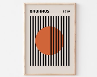 May include: A framed print with a black and white striped background and a large orange circle in the center. The text "BAUHAUS 1919" is at the top of the print.