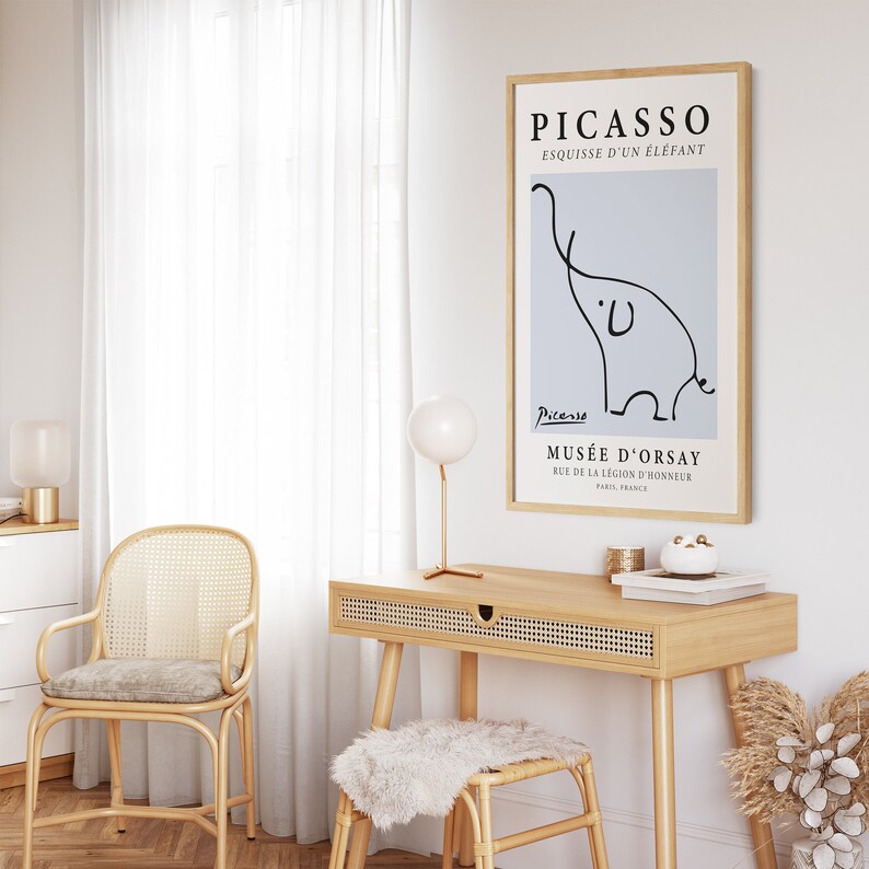 May include: A framed print of a black and white line drawing of an elephant by Pablo Picasso. The print is titled "Esquisse d'un &Eacute;l&eacute;phant" and includes the artist's signature and the museum's name, "Mus&eacute;e d'Orsay".