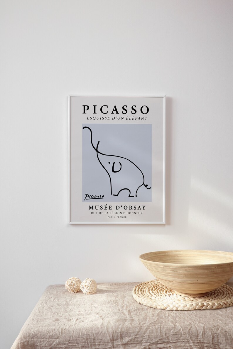 May include: A framed print of a black and white line drawing of an elephant by Pablo Picasso. The print is titled "Esquisse d'un &Eacute;l&eacute;phant" and includes the artist's signature and the name of the museum where the original artwork is located, Mus&eacute;e d'Orsay in Paris, France.