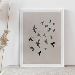 Pu&ograve; includere: Una stampa incorniciata con un design minimalista che presenta un gruppo di uccelli neri in silhouette su uno sfondo beige chiaro.