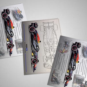 May include: A black and red Formula 1 race car with the Oracle logo and the words "Red Bull" and "Honda" on the side. The car is on a white background with a black outline.