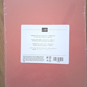 May include: A pack of 24 sheets of terracotta tile colored cardstock, wrapped in clear plastic. The label reads Stampin' Up! Terracotta Tile 8-1/2 x 11 Cardstock, 24 sheets total, acid free, lignin free, with a barcode and product number 150884.