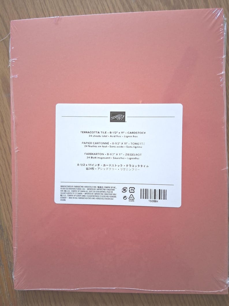 May include: A pack of 24 sheets of terracotta tile colored cardstock, wrapped in clear plastic. The label reads Stampin' Up! Terracotta Tile 8-1/2 x 11 Cardstock, 24 sheets total, acid free, lignin free, with a barcode and product number 150884.
