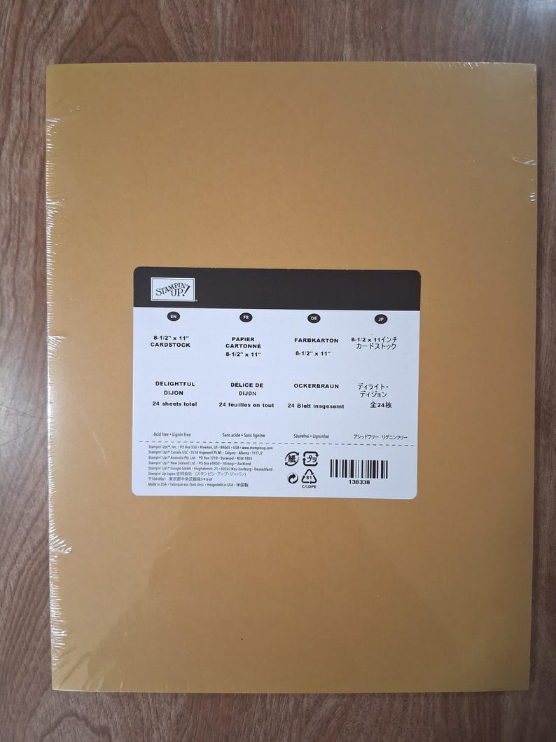May include: A pack of 24 sheets of 8-1/2 inch by 11 inch Delightful Dijon cardstock by Stampin' Up. The package is wrapped in clear plastic and features a white label with product details, including the color name and sheet count.