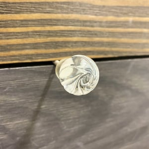 May include: A clear glass cabinet knob with a swirl design.